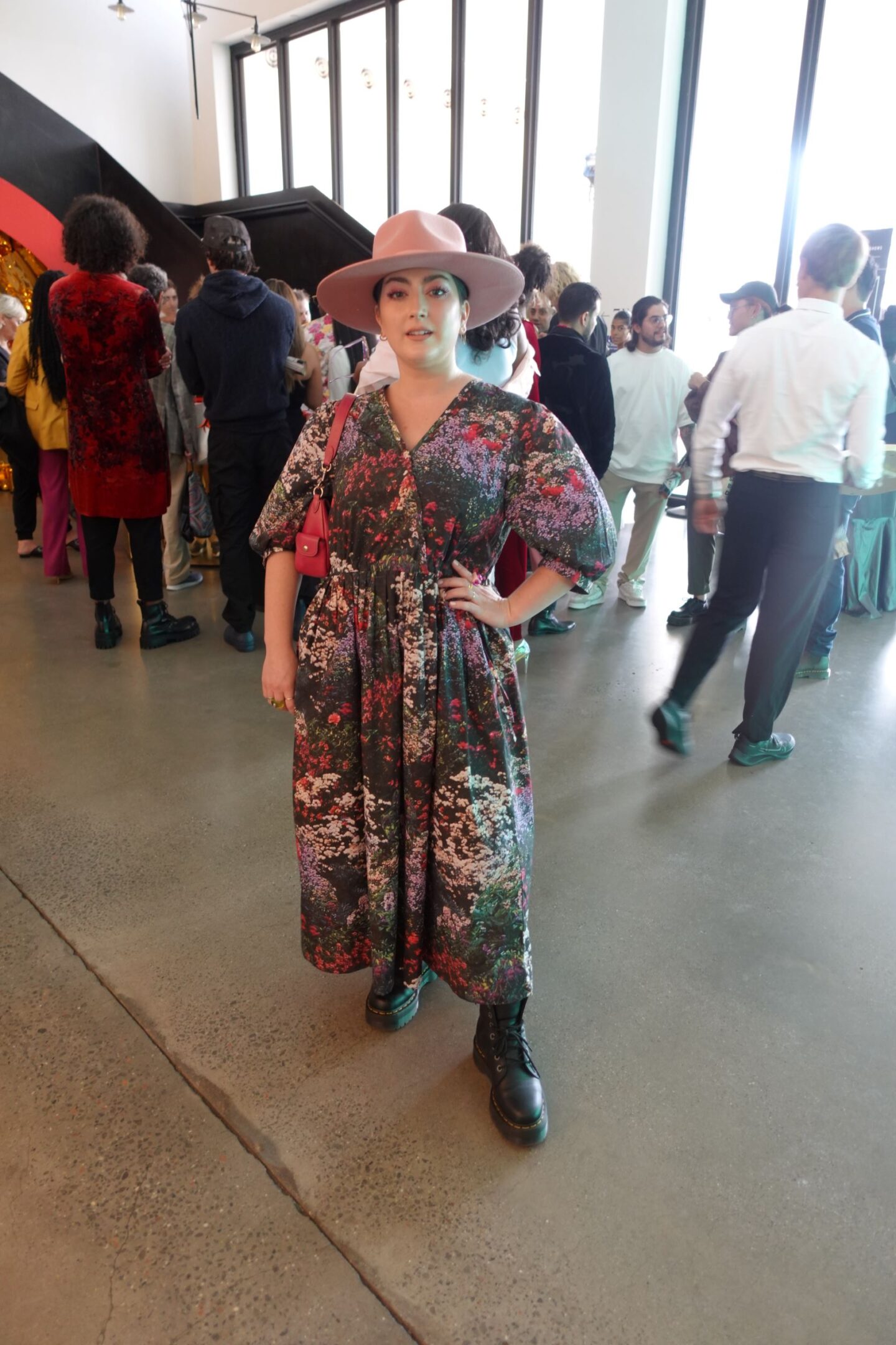 Fall outfit idea. Curvy woman in a dark floral dress and combat boots with a wide brim hat.